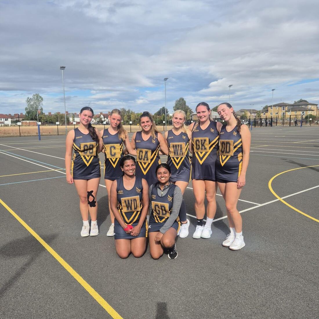 Eagles players standing together on outdoor netball courts