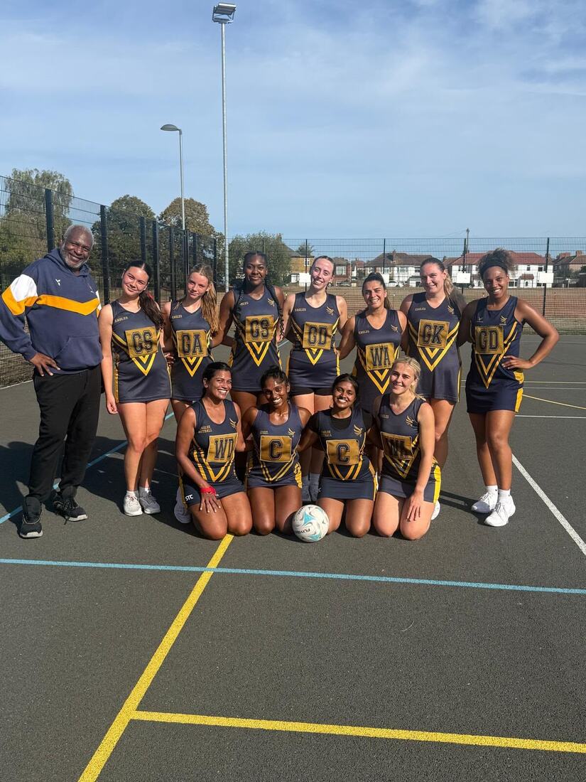 Eagles squad and coach on an outdoor court, front row kneeling with a match ball