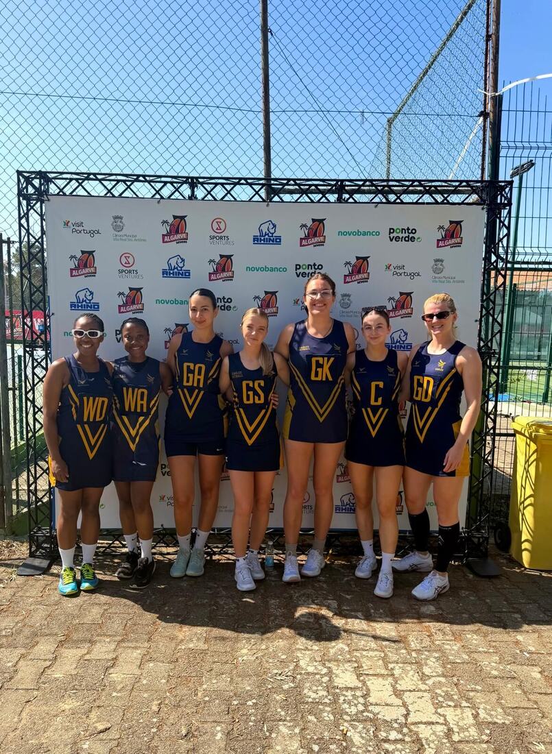 Eagles team in a line in front of a tournament sponsor board